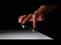 A person doing a trick with a fingerboard